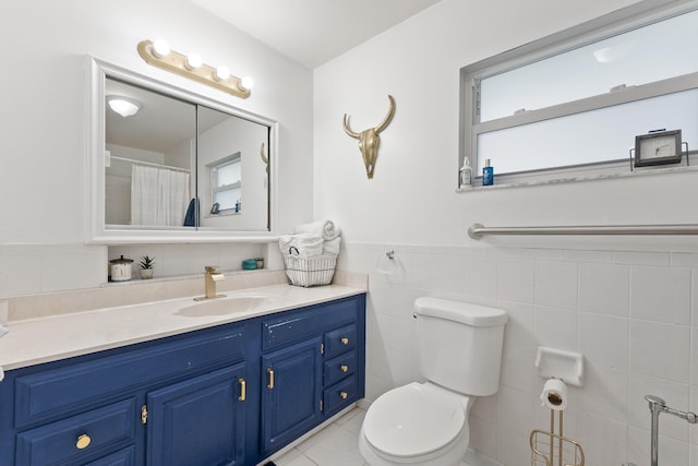 bathroom with vanity, tile walls, tile patterned floors, and toilet