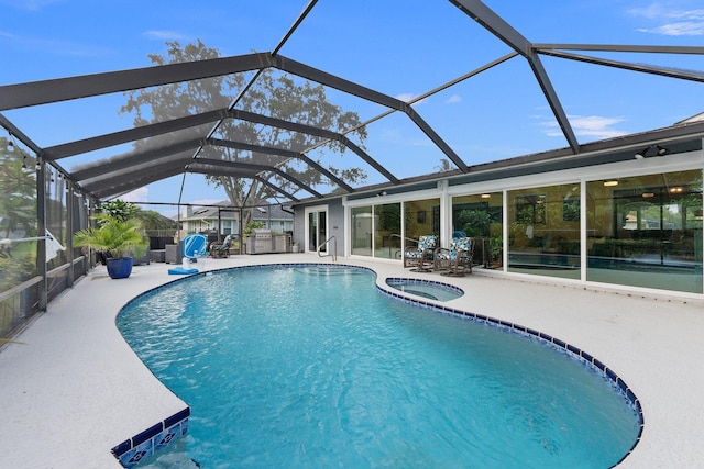 view of pool featuring a lanai, a patio area, and an in ground hot tub