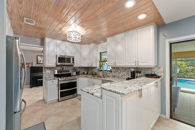 kitchen featuring white cabinetry, stainless steel appliances, and light stone counters