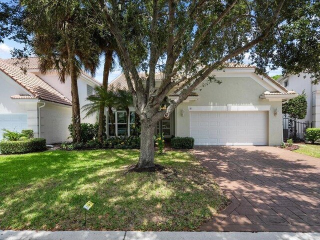 view of front of house featuring a garage and a front lawn