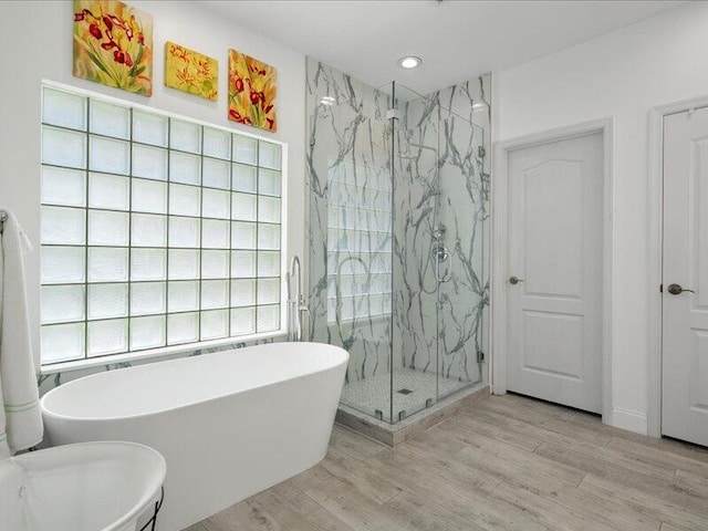 bathroom featuring plus walk in shower and wood-type flooring