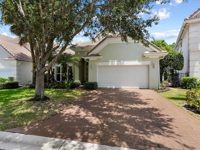 mediterranean / spanish home featuring a garage and a front yard