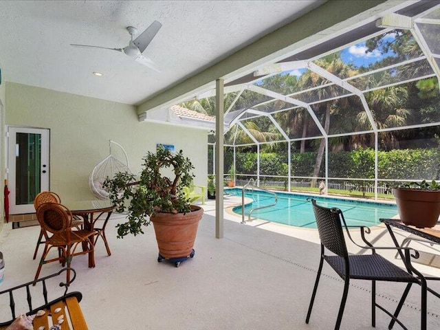 view of swimming pool with a lanai, a patio area, and ceiling fan