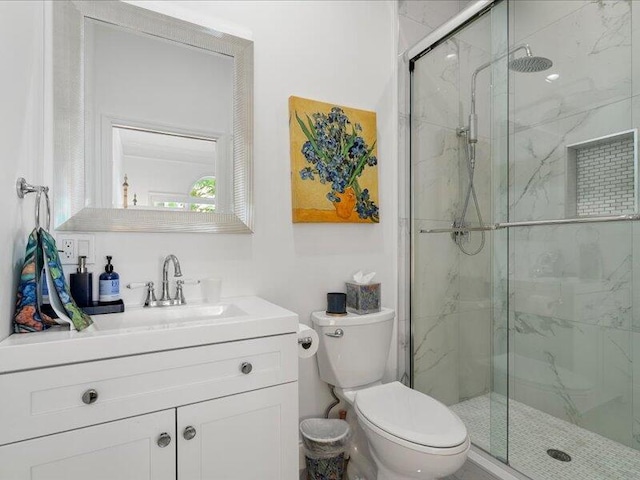 bathroom featuring vanity, an enclosed shower, and toilet