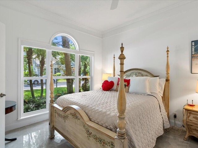 tiled bedroom with multiple windows, ceiling fan, and ornamental molding