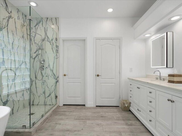 bathroom featuring independent shower and bath, vanity, and hardwood / wood-style floors