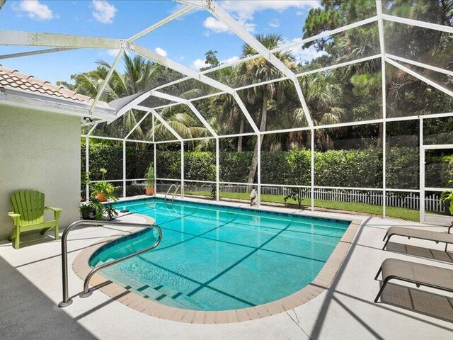 view of swimming pool with a patio area and glass enclosure