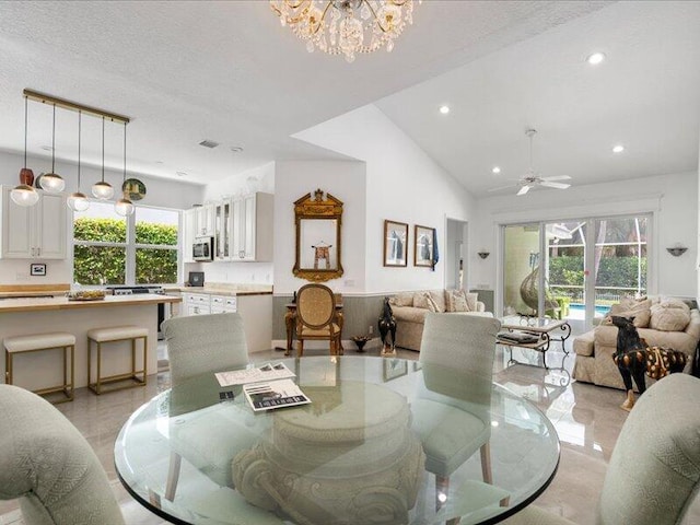 dining room featuring a textured ceiling, ceiling fan with notable chandelier, and high vaulted ceiling