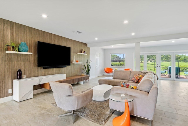 living room featuring wooden walls and french doors