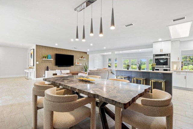 tiled dining space featuring a skylight