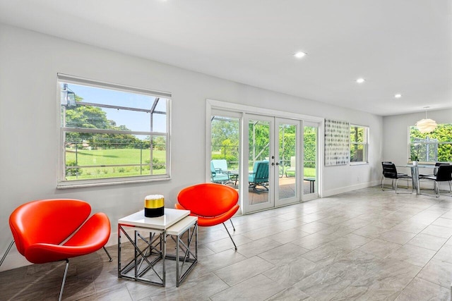 living area with plenty of natural light, french doors, and light tile patterned flooring