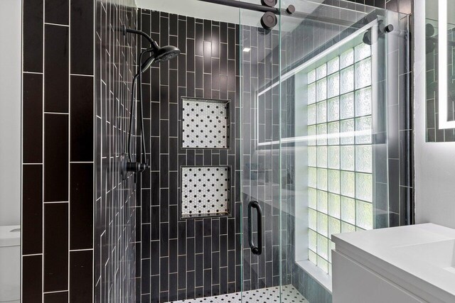 bathroom with vanity, an enclosed shower, and toilet