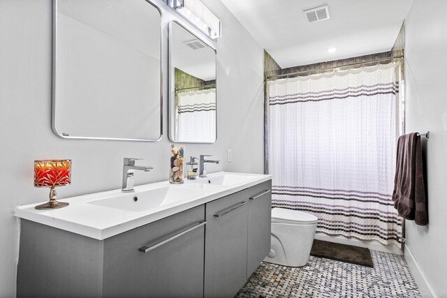 bathroom with double vanity, tile patterned flooring, and toilet