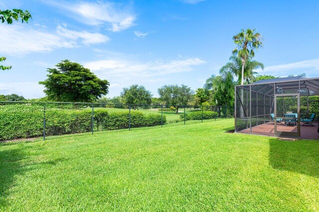 view of yard featuring a patio and glass enclosure