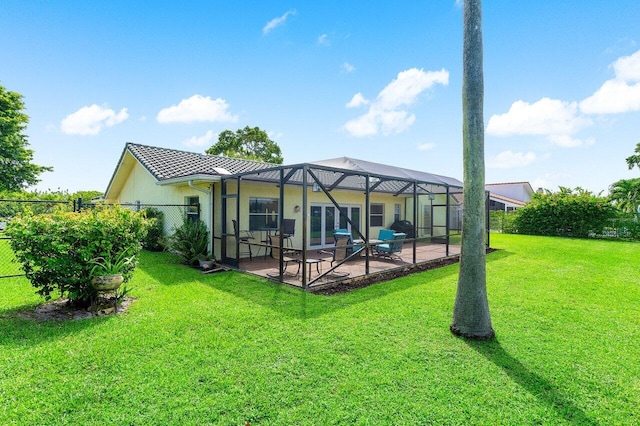 back of house featuring a yard, a lanai, and a patio area