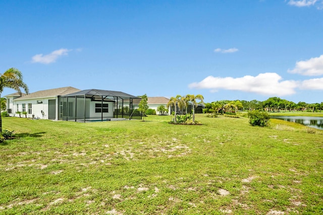 view of yard with a water view and a lanai