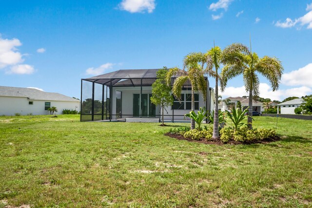 rear view of house featuring a yard and a lanai