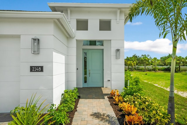 view of exterior entry featuring a yard