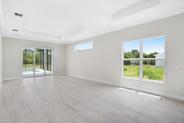 unfurnished room with light hardwood / wood-style flooring and a raised ceiling