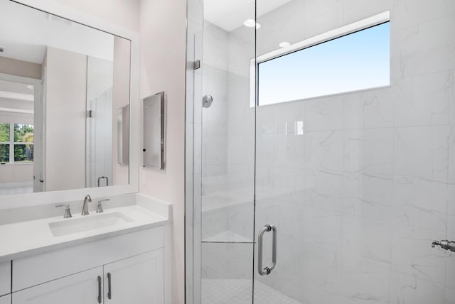 bathroom featuring a shower with shower door and vanity