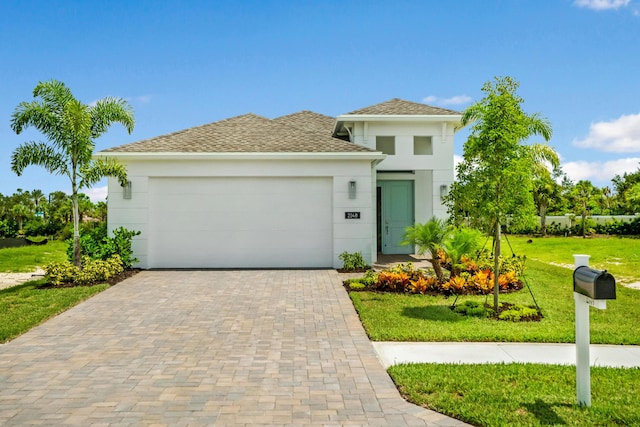 view of front of property with a garage and a front lawn