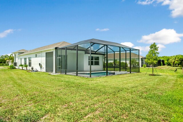 back of property with a patio area, a lanai, and a lawn