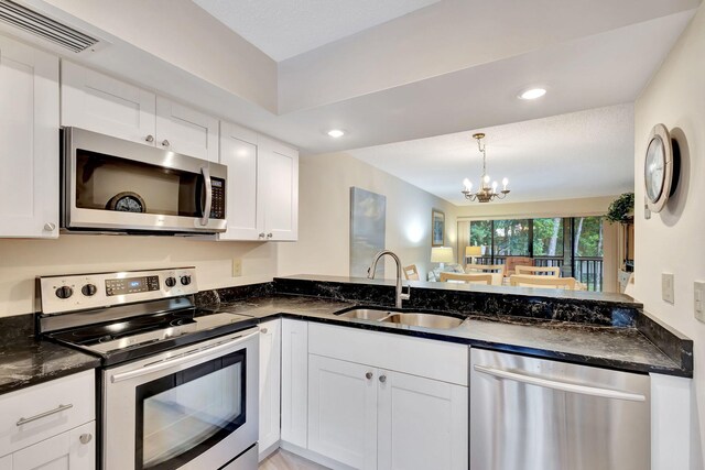 kitchen with decorative light fixtures, a chandelier, stainless steel appliances, white cabinets, and sink