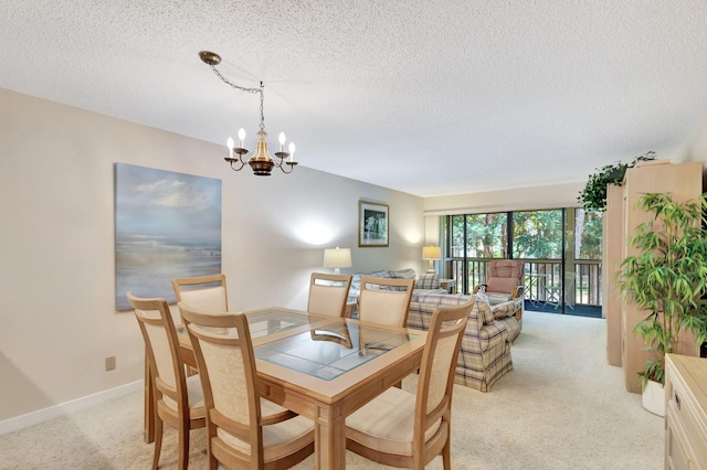 dining area featuring a notable chandelier, a textured ceiling, and light carpet