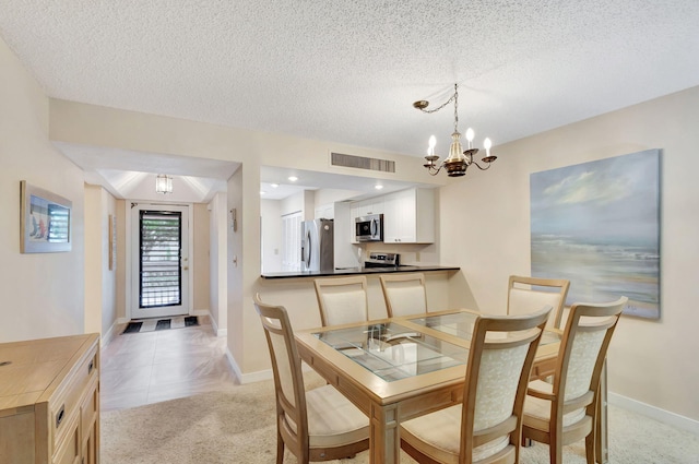 carpeted dining area with a textured ceiling and an inviting chandelier