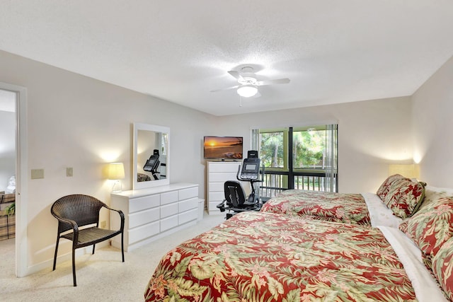 bedroom featuring ceiling fan, light colored carpet, and a textured ceiling