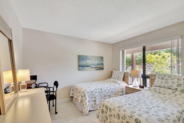 bedroom featuring a textured ceiling and light carpet