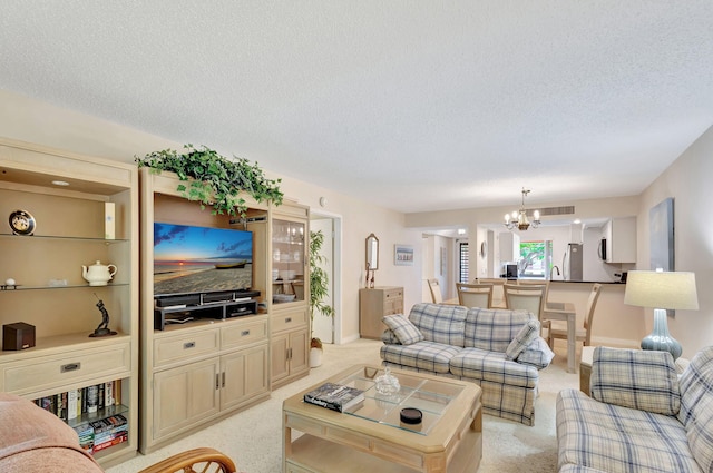 carpeted living room with a textured ceiling and a chandelier