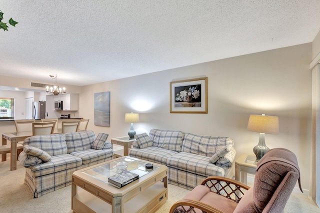 living room featuring a textured ceiling, light carpet, and an inviting chandelier