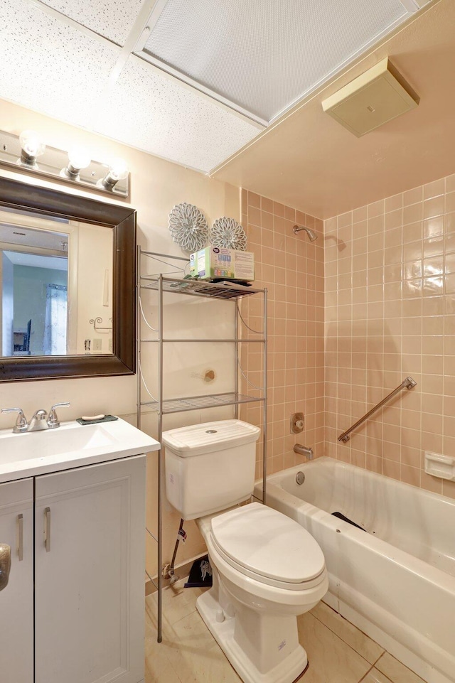 full bathroom with vanity, tiled shower / bath, a paneled ceiling, toilet, and tile patterned flooring