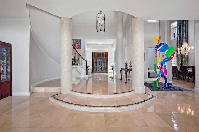 tiled entrance foyer with a textured ceiling and an inviting chandelier