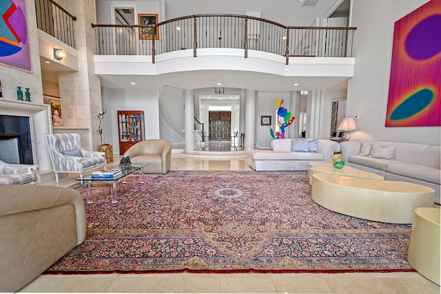 tiled living room with a tile fireplace and a towering ceiling