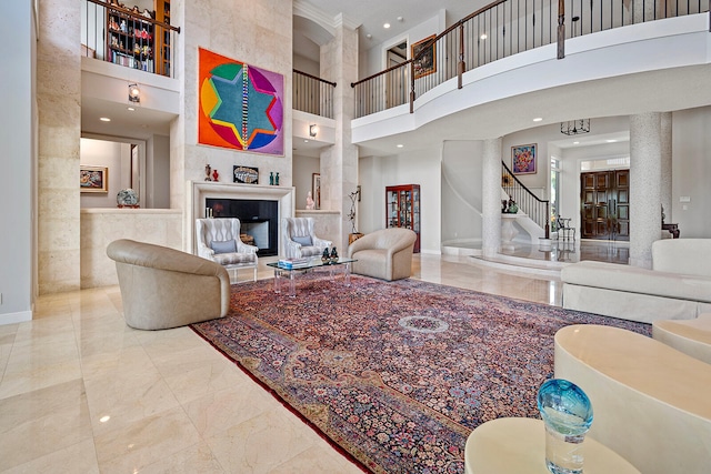 tiled living room with a fireplace, ornamental molding, and a high ceiling