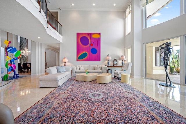 living room with tile patterned flooring, a towering ceiling, a notable chandelier, and crown molding