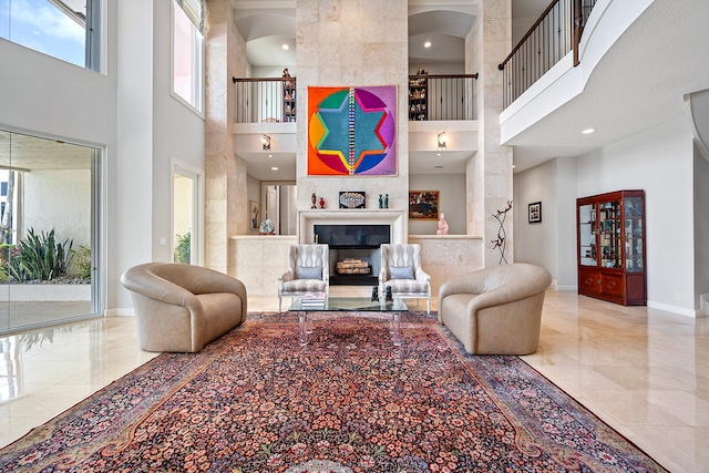 tiled living room with a large fireplace, decorative columns, and a high ceiling