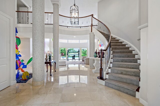 tiled foyer featuring a high ceiling and a notable chandelier