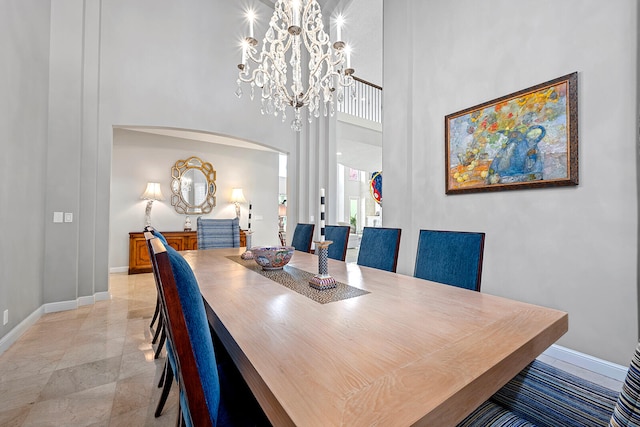 tiled dining room with a high ceiling and a chandelier