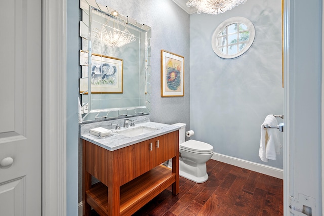 bathroom featuring wood-type flooring, crown molding, toilet, and vanity