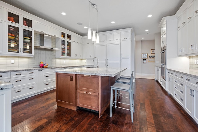 kitchen with backsplash, white cabinetry, and dark hardwood / wood-style floors