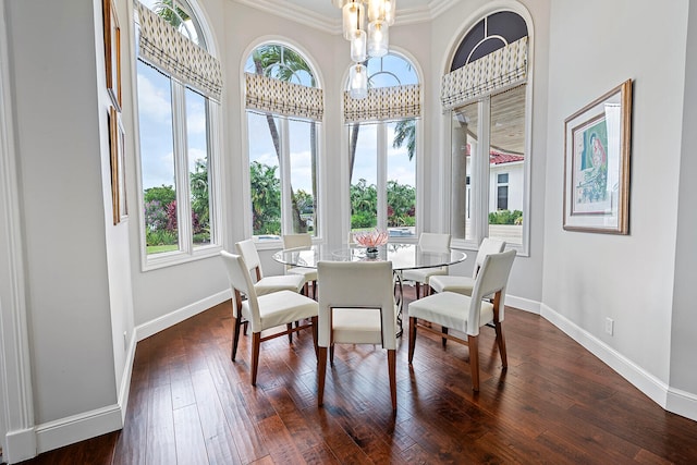 dining room with crown molding, dark hardwood / wood-style flooring, and an inviting chandelier