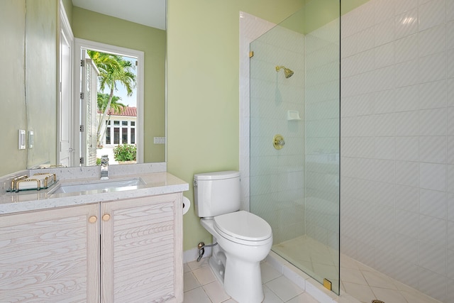 bathroom featuring vanity, toilet, a shower with door, and tile patterned flooring