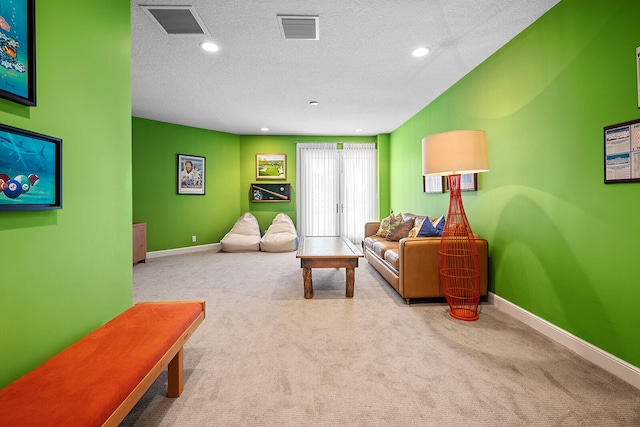 carpeted living room featuring a textured ceiling