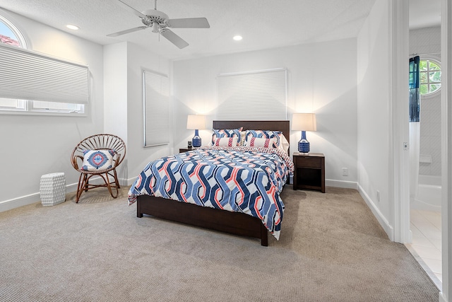 carpeted bedroom featuring ensuite bathroom, a textured ceiling, and ceiling fan