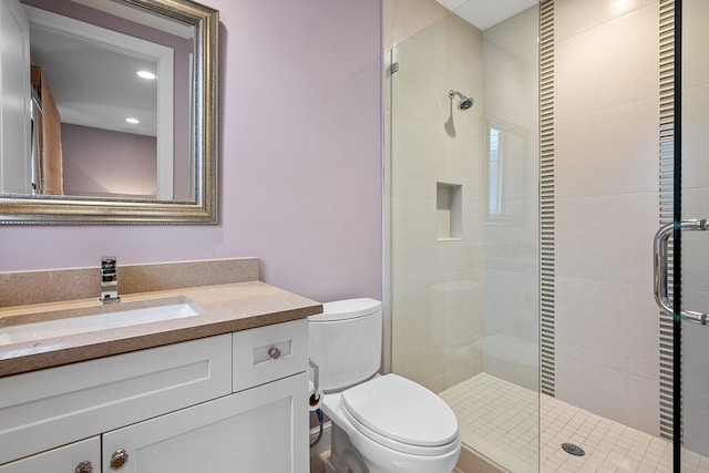 bathroom featuring vanity, an enclosed shower, and toilet