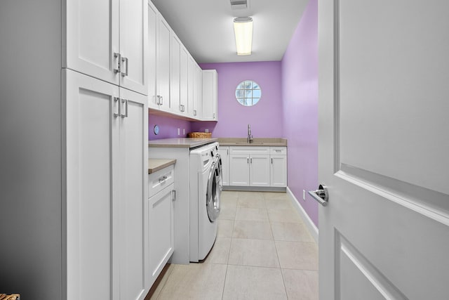 laundry room featuring sink, cabinets, and light tile patterned floors