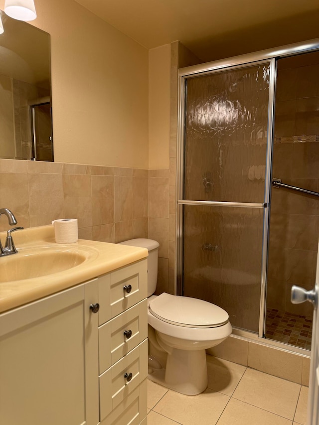 bathroom featuring tile walls, vanity, an enclosed shower, tile patterned floors, and toilet